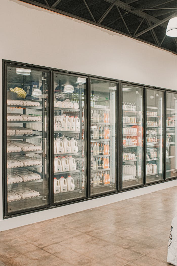 Well-stocked grocery store refrigerator displaying dairy products and beverages.